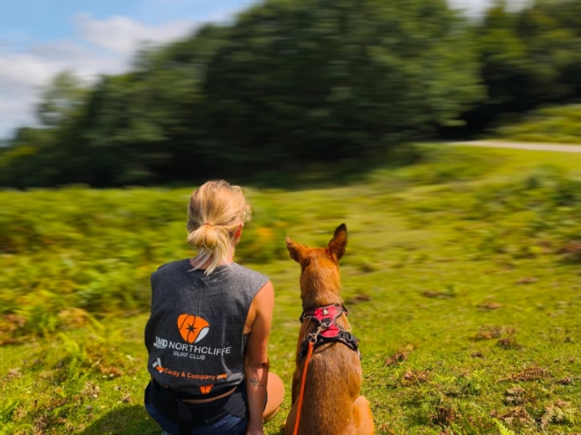 Lucille en reconversion pet-sitter, de dos avec un chien en pleine nature dans les Landes